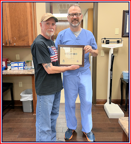 Registrar Dennis Beckham presents Pat Smithwith a Military Veterans Certificate for his service in the United States Navy.